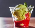 Green Organic Avocado Ice Cream and Strawberry Sorbet with red wine in a plastic cup with mint Royalty Free Stock Photo