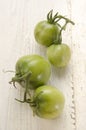 Green organic tomato on white wood Royalty Free Stock Photo