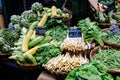 Green organic vegetables in display for sale at a street food market, with names displayed in English, globe artichokes, white asp Royalty Free Stock Photo