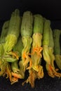 Green organic zucchini stack with blossoms closeup