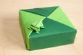 Green origami frog on top of origami box lid