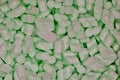 Green packing foam peanuts Styrofoam popcorn packaging noodles material closeup.