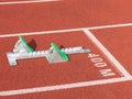 Green padded track and field starting blocks on a red track Royalty Free Stock Photo