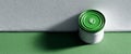Green paint can with arrow symbol on lid casting shadow on textured green and white wall surface Royalty Free Stock Photo