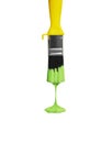 Green paint dripping from the yellow brush, isolated on white. Royalty Free Stock Photo
