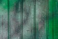 Green paint on old dirty fence surface weathered texture background