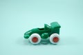 Green paint plastic toy racing car with number one isolated on turquoise Royalty Free Stock Photo