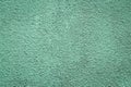 Green painted concrete wall. Texture of plaster, stucco. Grunge stone background, whitewash wallpaper