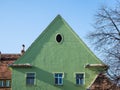 Green painted facade of an old house in the medieval town of Sighisoara, Romania Royalty Free Stock Photo