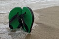 Green pair of sandals on the beach. Summer holiday concept Royalty Free Stock Photo