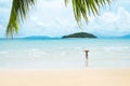 Green palm tree leaf and young woman standing near sea Royalty Free Stock Photo