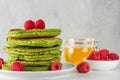 Green pancakes with matcha tea, raspberries and honey. healthy breakfast dessert Royalty Free Stock Photo