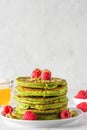 Green pancakes with matcha tea, raspberries, pistachios and honey. healthy breakfast. vertical orientation Royalty Free Stock Photo