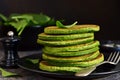 Green pancakes with spinach and cream sauce on a dark background. Organic Food