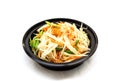 Thai papaya salad, Som Tum from Thailand served in black bowl on white background. topping with peanuts.