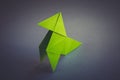 Green paper hen origami isolated on a grey background