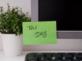 Green paper notes with the reminder Tax Day on it sticked on to a monitor at an office workplace Royalty Free Stock Photo