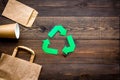 Green paper recycling sign among waste material paper on dark wooden background top view space for text Royalty Free Stock Photo