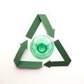 Green paper recycling symbol with empty plastic water bottles Royalty Free Stock Photo