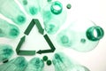 Green paper recycling symbol with empty plastic water bottles Royalty Free Stock Photo