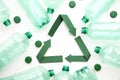 Green paper recycling symbol with empty plastic water bottles Royalty Free Stock Photo