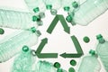 Green paper recycling symbol with empty plastic water bottles Royalty Free Stock Photo