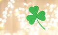 Green paper shamrock over festive lights Royalty Free Stock Photo