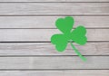 Green paper shamrock on wooden background Royalty Free Stock Photo