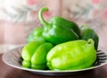 Green paprika / pepper on metal plate and wooden broun table.