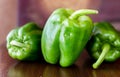 Green paprika / pepper on wooden broun table.