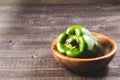 Green paprika on a wooden bowl/Green paprika pepper on a wooden bowl over dark background. Copy space