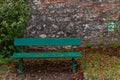 Empty Green park bench with wall and green leaves of the ivy Royalty Free Stock Photo