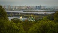 Green park and temple on the background of the river and the modern city. Botanical Garden in Kiev.