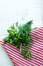 Green parsley and dill leaves on natural linen napkin on wooden background Royalty Free Stock Photo