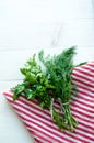 Green parsley and dill leaves on natural linen napkin on wooden background Royalty Free Stock Photo