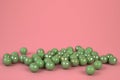 Green pastel marbles at soft pink background. Creative minimal concept