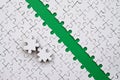 The green path is laid on the platform of a white folded jigsaw puzzle. The missing elements of the puzzle are stacked nearby. Tex Royalty Free Stock Photo