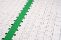 The green path is laid on the platform of a white folded jigsaw puzzle. Texture image with copy space for text Royalty Free Stock Photo