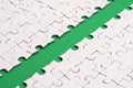 The green path is laid on the platform of a white folded jigsaw puzzle. Texture image with copy space for text Royalty Free Stock Photo