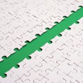 The green path is laid on the platform of a white folded jigsaw puzzle. Texture image with copy space for text Royalty Free Stock Photo