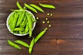 Green pea in a plate on wooden background. Top view, close-up, copy with space.