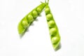 Green pea pods with young beans. Green peas on the table. On a white background is an open pod of green peas. Royalty Free Stock Photo