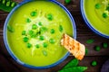 Green pea soup on wooden rustic background