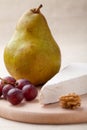 Green pear, cheese brie, walnut, grapes Royalty Free Stock Photo