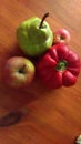 Green pear, two red apples and red sweet pepper on wooden table Royalty Free Stock Photo