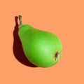 Green pear. Ripe juicy pear on an orange background close-up. Ripe fruit Royalty Free Stock Photo