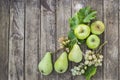 Green pears , apples and grape with leafs on old, wooden table. Royalty Free Stock Photo