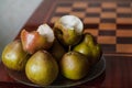 Green pears lie on plate next to chessboard Royalty Free Stock Photo