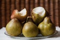 Green pears lie on plate. On top are bitten pears.