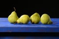 Green pears sitting on a blue table